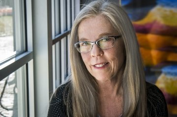 Poet Laureat Kari Gunter-Semour is picture beside window.